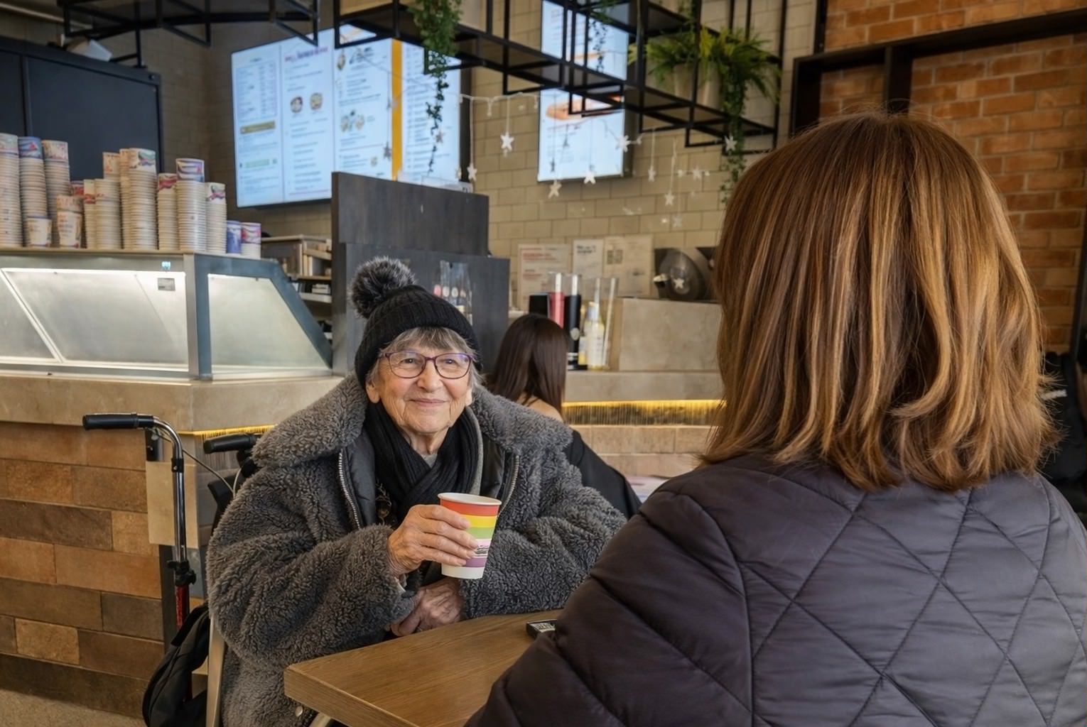 Service User having a cup of coffee, accompanied by carer